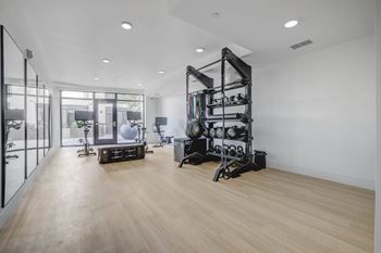 A gym with a weight rack and exercise equipment.
